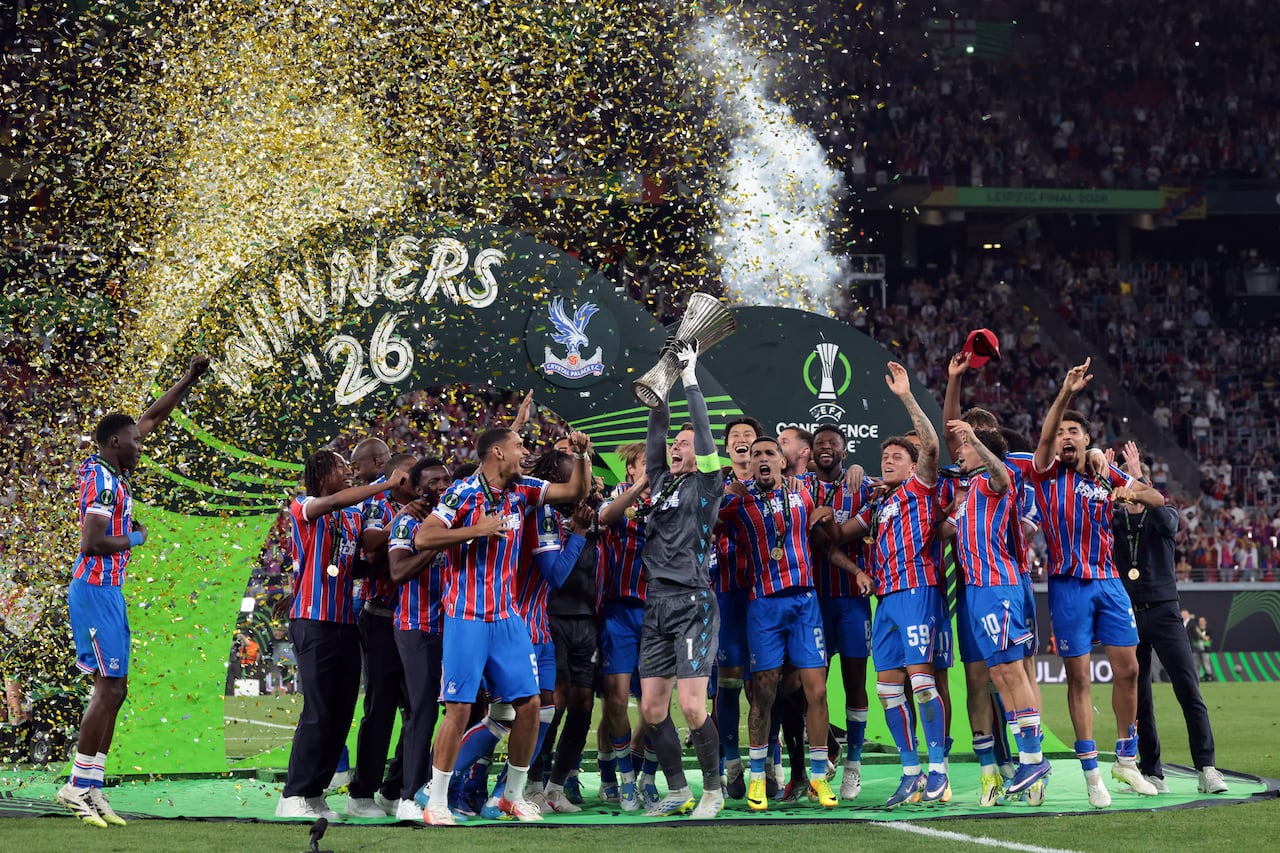 El portero inglés del Crystal Palace, Dean Henderson (C), levanta el trofeo mientras su equipo celebra la victoria en la final de la Liga de Conferencia de la UEFA entre el Crystal Palace FC y el Rayo Vallecano de Madrid en Leipzig, Alemania Oriental, el 27 de mayo de 2026. (Foto de Tobias SCHWARZ / AFP)