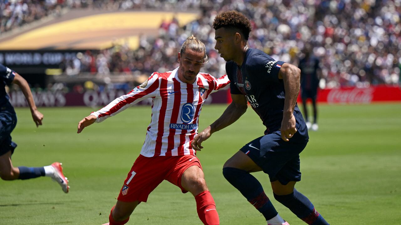 Antoine Griezmann (izq.) lucha por el balón con el centrocampista francés #14 del Paris Saint-Germain, Desire Doue.