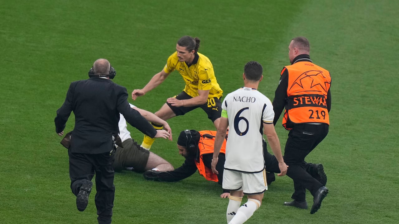 Dortmund's Marcel Sabitzer, second left, and stewards chase a pitch invader during the Champions League final soccer match between Borussia Dortmund and Real Madrid at Wembley stadium in London, Saturday, June 1, 2024. (AP Photo/Alastair Grant)