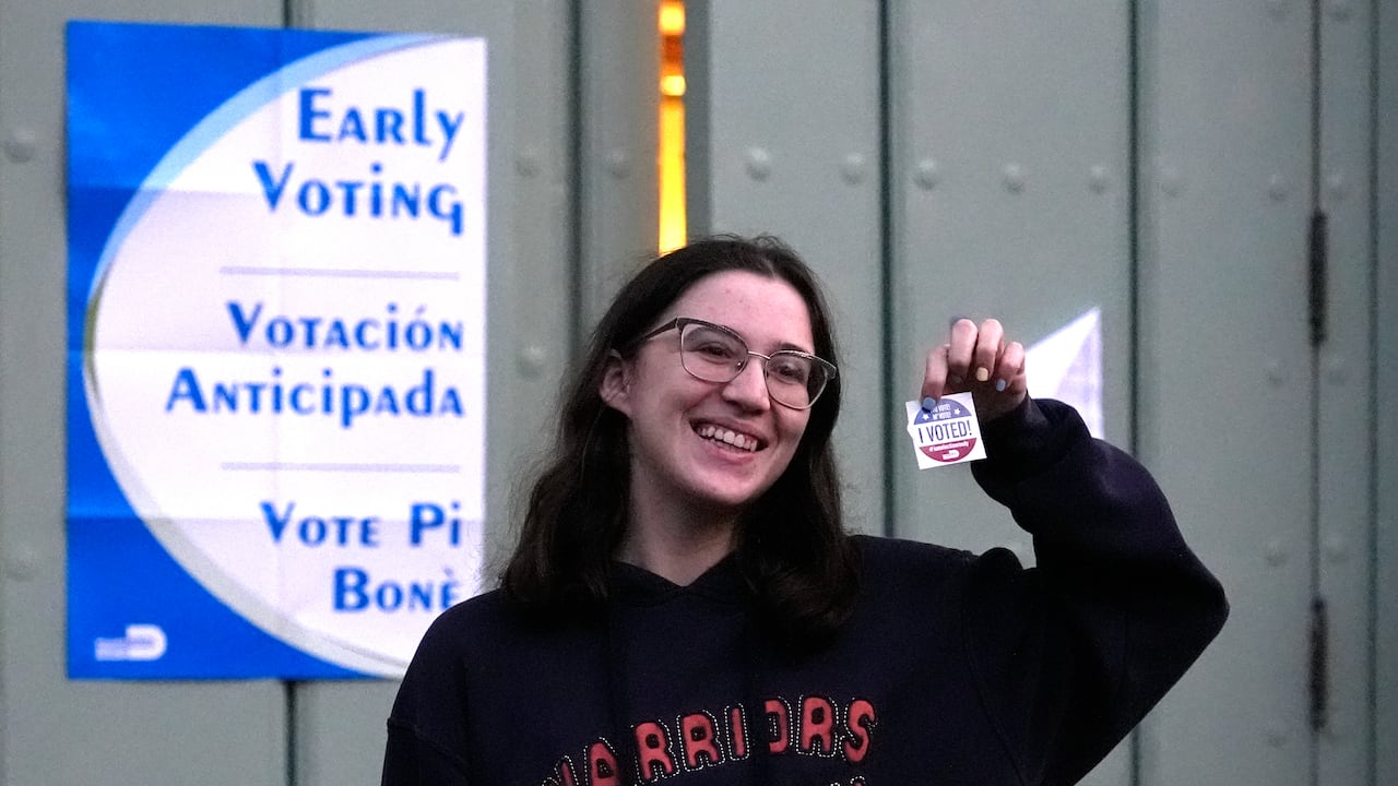 Ashley Herman muestra una calcomanía luego de haber votado en el primer día de la votación anticipada de las elecciones generales de Estados Unidos, el lunes 21 de octubre de 2024, en Miami. (AP Foto/Lynne Sladky)