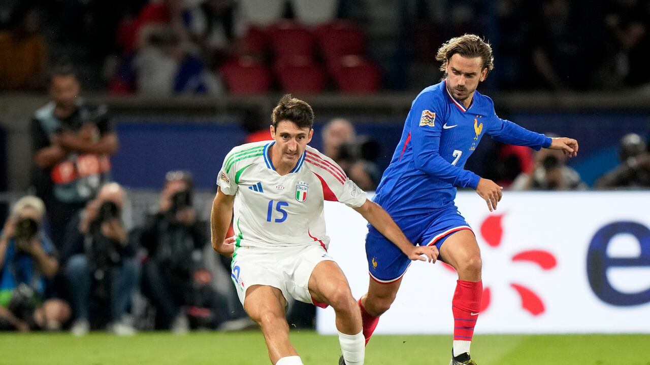 El francés Antoine Griezmann disputa el balón con el italiano Andrea Cambiasso, a la izquierda, durante el partido de fútbol de la Liga de Naciones de la UEFA entre Francia e Italia en el Parque de los Príncipes en París, el viernes 6 de septiembre de 2024. (Foto AP/Michel Euler)
