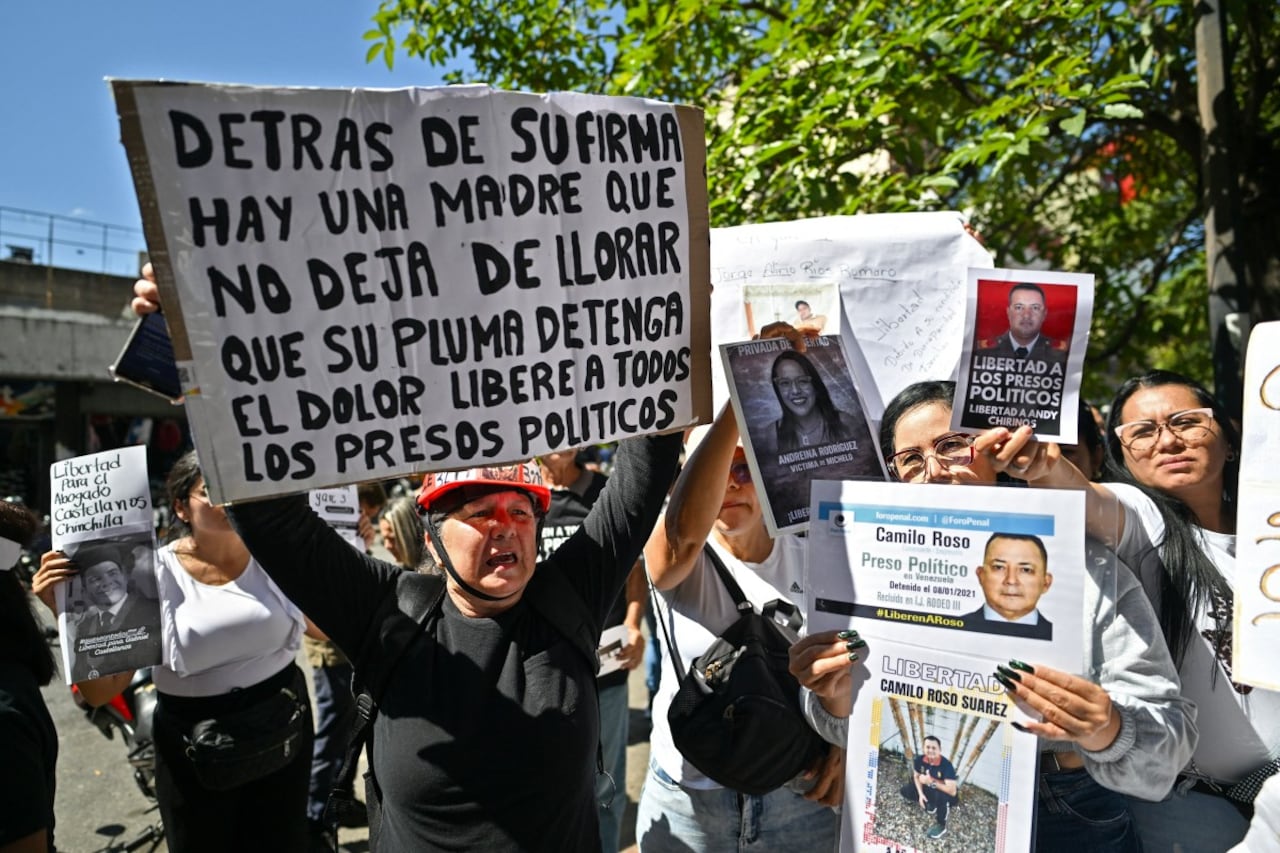 Familiares de presos políticos se manifiestan exigiendo su liberación con sus fotos y un cartel que dice "Detrás de tu firma hay una madre que no deja de llorar.