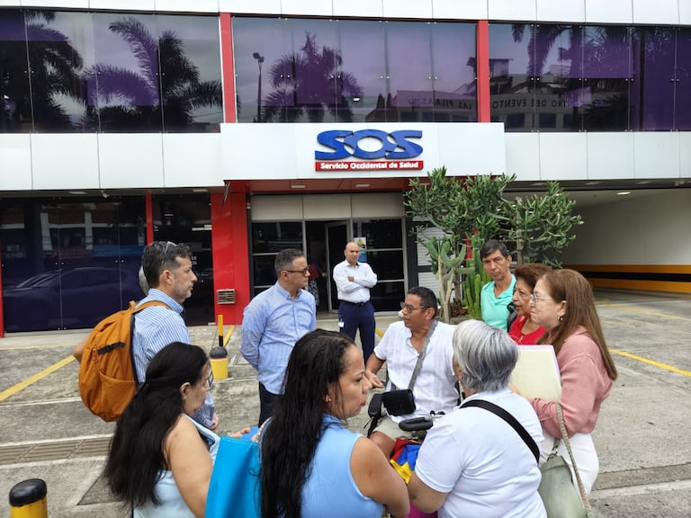 Usuarios de la EPS Servicio Occidental de Occidente SOS se reúnen a las afueras de esta entidad.