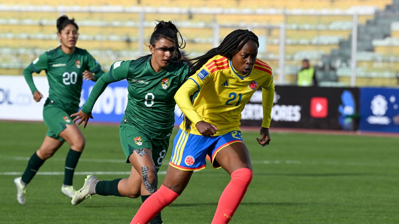 La delantera colombiana #21 Valerin Loboa corre con el balón superando a la mediocampista boliviana #08 Ruth Soliz durante el partido de fútbol de la Liga de Naciones Femenina Conmebol 2025-26 entre Bolivia y Colombia en el Estadio Hernando Siles en La Paz el 28 de noviembre de 2025. (Foto de Aizar RALDES / AFP)