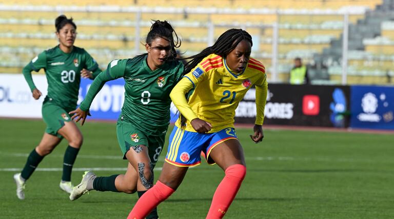 La delantera colombiana #21 Valerin Loboa corre con el balón superando a la mediocampista boliviana #08 Ruth Soliz durante el partido de fútbol de la Liga de Naciones Femenina Conmebol 2025-26 entre Bolivia y Colombia en el Estadio Hernando Siles en La Paz el 28 de noviembre de 2025. (Foto de Aizar RALDES / AFP)