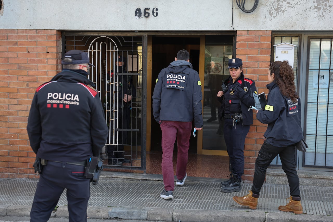 Un agente de policía entra al edificio donde se registró el incendio, que también dejó cuatro personas heridas, cerca de Barcelona en España.