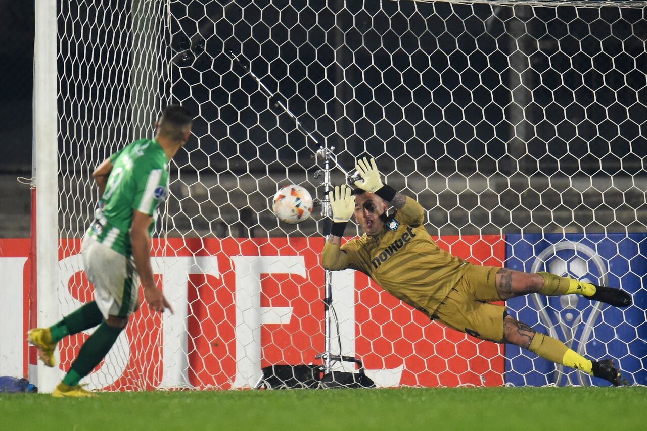 El portero de Huachipato, Fabián Cerda (D), detiene el tiro penal del delantero de Racing, Dylan Nandin.