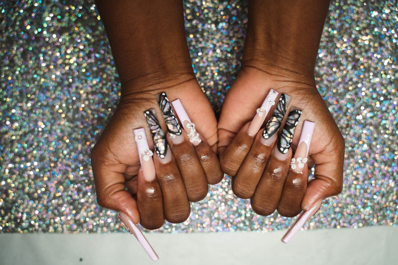 African American women getting an acrylic manicure.