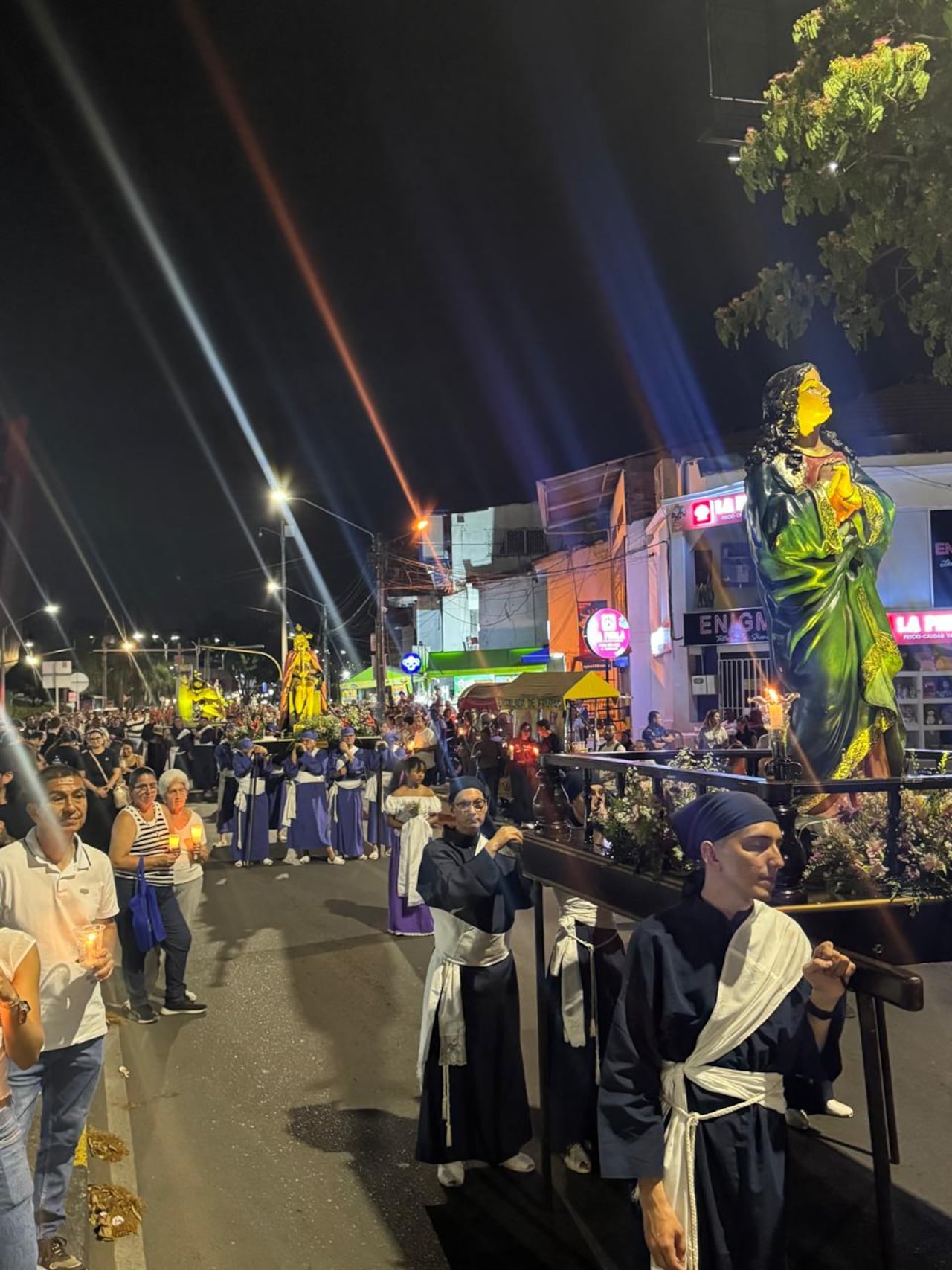 Con cirios y flores en mano, los asistentes recorrieron las calles junto a los pasos que representan la pasión de Jesucristo.