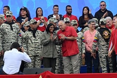 La presidenta interina de Venezuela, Delcy Rodríguez (C, izquierda), escucha al ministro del Interior, Justicia y Paz, Diosdado Cabello, durante un desfile cívico-militar