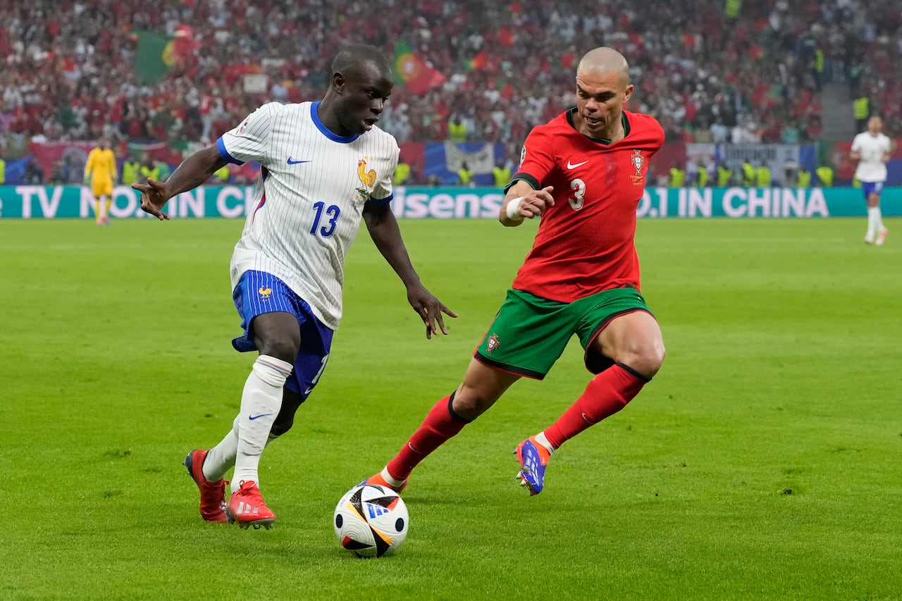 N'Golo Kante de Francia, izquierda, y Pepe de Portugal compiten por el balón durante un partido de cuartos de final entre Portugal y Francia en el torneo de fútbol Euro 2024 en Hamburgo, Alemania, el viernes 5 de julio de 2024. (Foto AP/Frank Augstein)