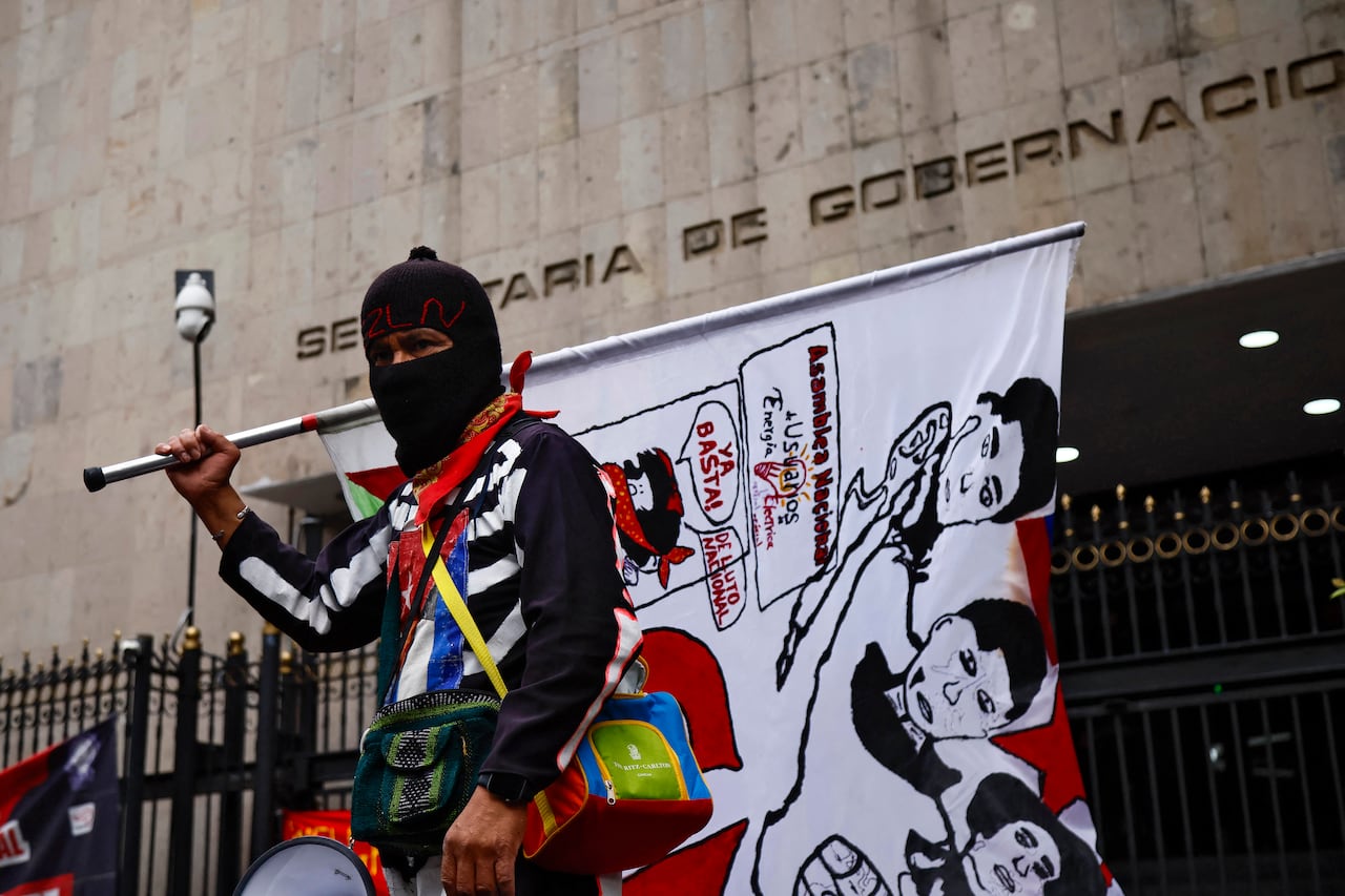 Un manifestante con una bandera del Ejército Zapatista de Liberación Nacional (EZLN) participa en una manifestación organizada por la Coordinadora Nacional de Trabajadores de la Educación (CNTE) antes del inicio de la Copa Mundial de la FIFA 2026, frente al edificio de la Secretaría de Gobernación en la Ciudad de México, el 10 de junio de 2026. (Foto de Rodrigo Oropeza / AFP)