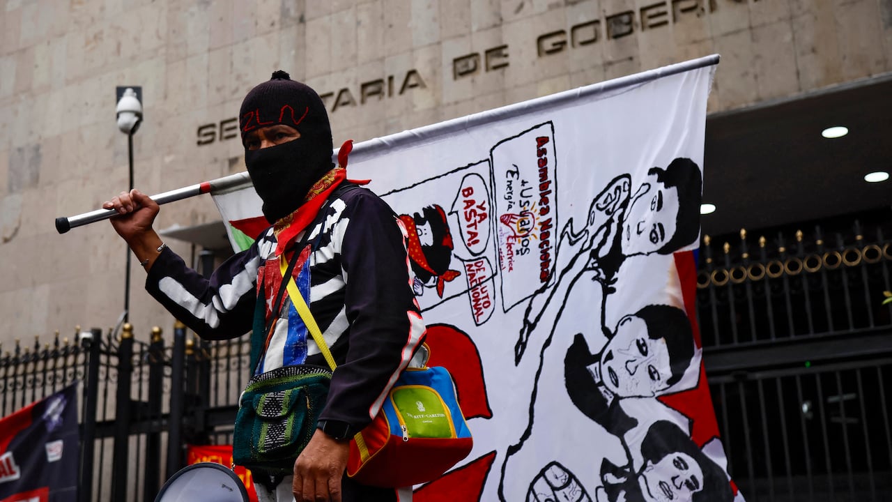 Un manifestante con una bandera del Ejército Zapatista de Liberación Nacional (EZLN) participa en una manifestación organizada por la Coordinadora Nacional de Trabajadores de la Educación (CNTE) antes del inicio de la Copa Mundial de la FIFA 2026, frente al edificio de la Secretaría de Gobernación en la Ciudad de México, el 10 de junio de 2026. (Foto de Rodrigo Oropeza / AFP)