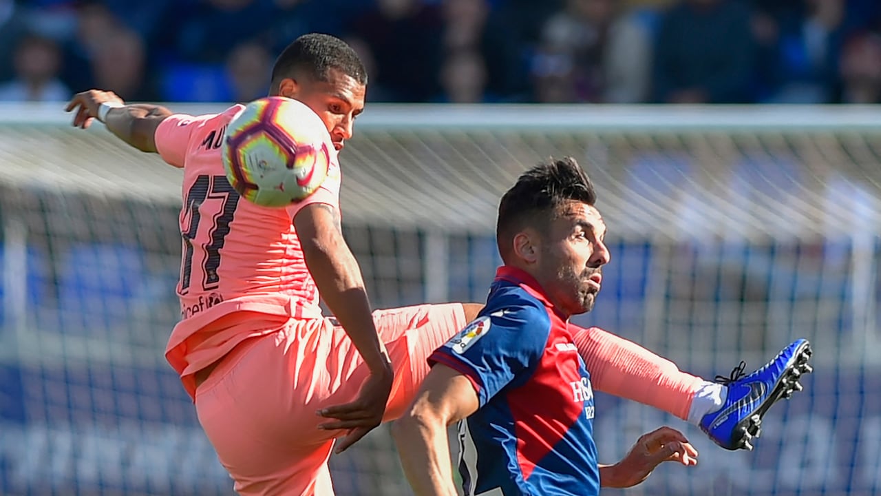 El defensa colombiano del Barcelona Jeison Murillo (izq.) compite con el delantero español del SD Huesca Enric Gallego durante el partido de la liga española entre el SD Huesca y el FC Barcelona en el estadio El Alcoraz en Huesca el 13 de abril de 2019. (Foto de ANDER GILLENEA / AFP)