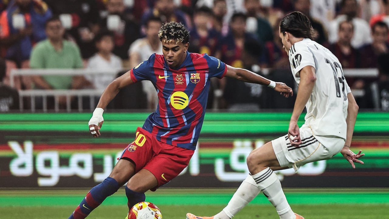 El delantero español #10 del Barcelona, Lamine Yamal (izq.), y el defensa español #18 del Real Madrid, Álvaro Carreras, luchan por el balón durante la final de la Supercopa de España entre el FC Barcelona y el Real Madrid en el Estadio Rey Abdullah en Yeddah el 11 de enero de 2026. (Foto de Fadel SENNA / AFP)