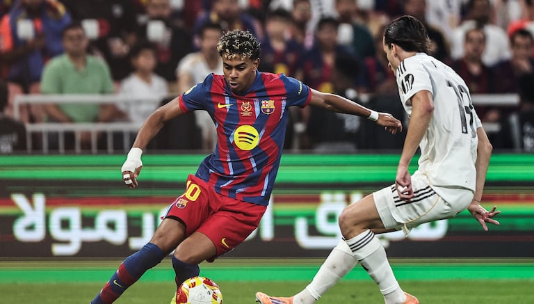 El delantero español #10 del Barcelona, Lamine Yamal (izq.), y el defensa español #18 del Real Madrid, Álvaro Carreras, luchan por el balón durante la final de la Supercopa de España entre el FC Barcelona y el Real Madrid en el Estadio Rey Abdullah en Yeddah el 11 de enero de 2026. (Foto de Fadel SENNA / AFP)