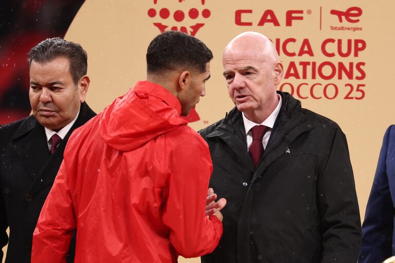 El príncipe Moulay Rachid (izq.) de Marruecos observa mientras el defensa marroquí #02 Achraf Hakimi habla con el presidente de la FIFA Gianni Infantino durante la presentación al final de la final de la Copa Africana de Naciones (CAN) entre Senegal y Marruecos en el Estadio Príncipe Moulay Abdellah en Rabat el 18 de enero de 2026. (Foto de FRANCK FIFE / AFP)