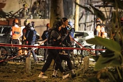 Una mujer herida es escoltada a un lugar seguro en el lugar de un ataque con misiles iraníes en Tel Aviv el 28 de febrero de 2026. Estados Unidos e Israel lanzaron ataques contra Irán el 28 de febrero