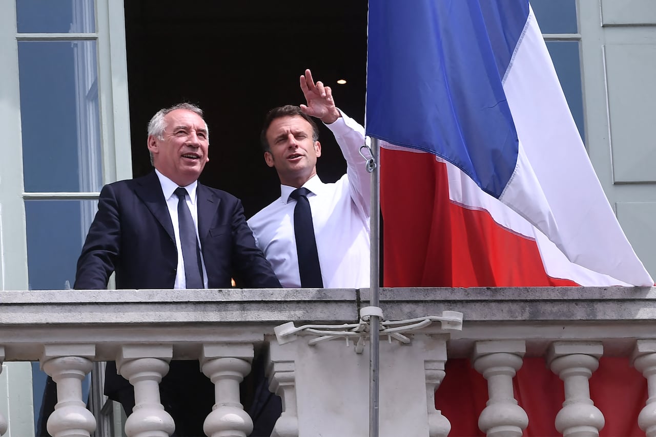 (ARCHIVO) El presidente francés Emmanuel Macron (R) posa con el presidente francés del partido Módem Francois Bayrou y el alcalde de Pau Francois Bayrou (I) en el balcón del ayuntamiento durante una visita a Pau, suroeste de Francia, el 6 de julio de 2023.