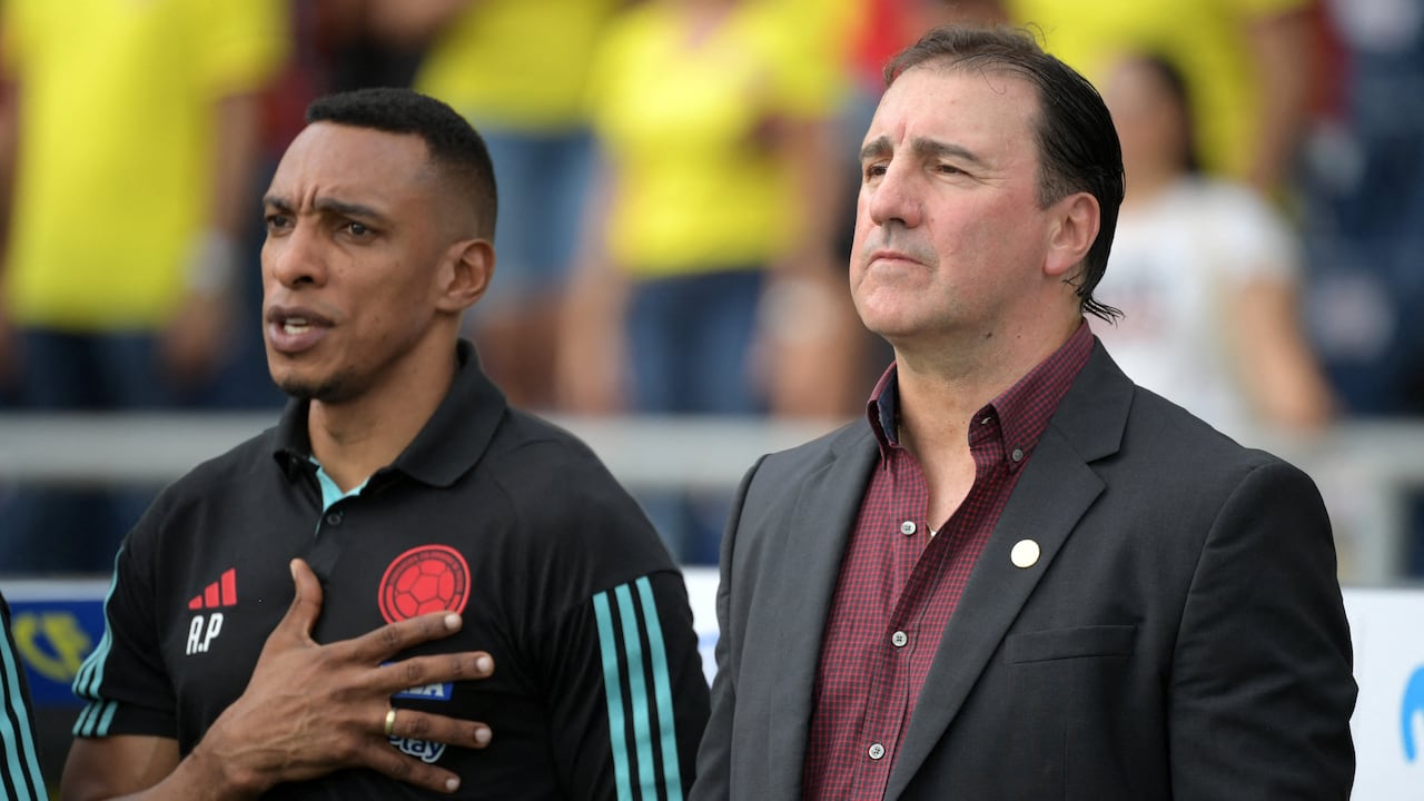El entrenador argentino de Colombia, Néstor Lorenzo (R) y el entrenador asistente colombiano Luis Amaranto Perea escuchan los himnos antes del inicio del partido de fútbol de clasificación sudamericano para la Copa Mundial de la FIFA 2026 entre Colombia y Uruguay en el Estadio Metropolitano Roberto Meléndez en Barranquilla, Colombia, en octubre. 12 de diciembre de 2023. (Foto de Raúl ARBOLEDA / AFP)