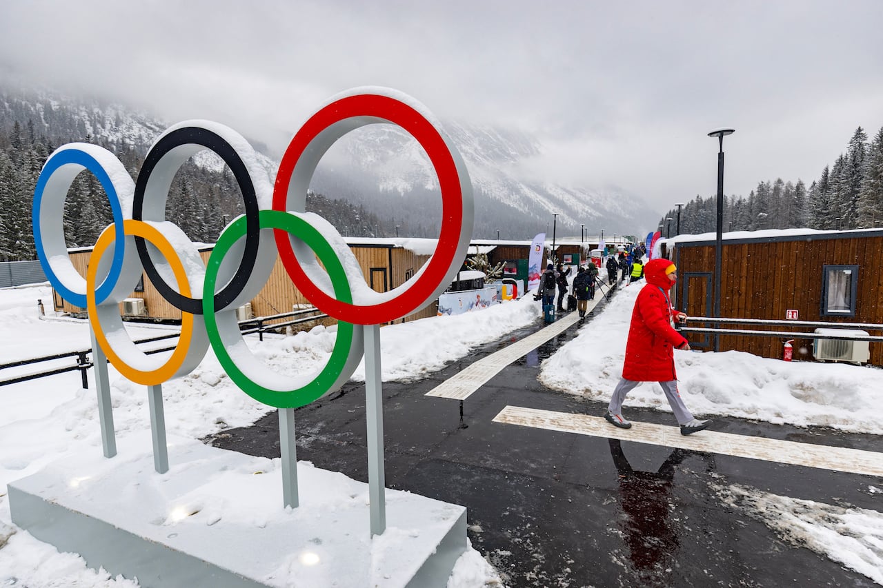 Un miembro del equipo alemán camina junto a los anillos olímpicos en la Villa Olímpica antes de los Juegos Olímpicos de Invierno de Milán-Cortina 2026 en Cortina d'Ampezzo el 3 de febrero de 2026. (Foto de Odd ANDERSEN / AFP)