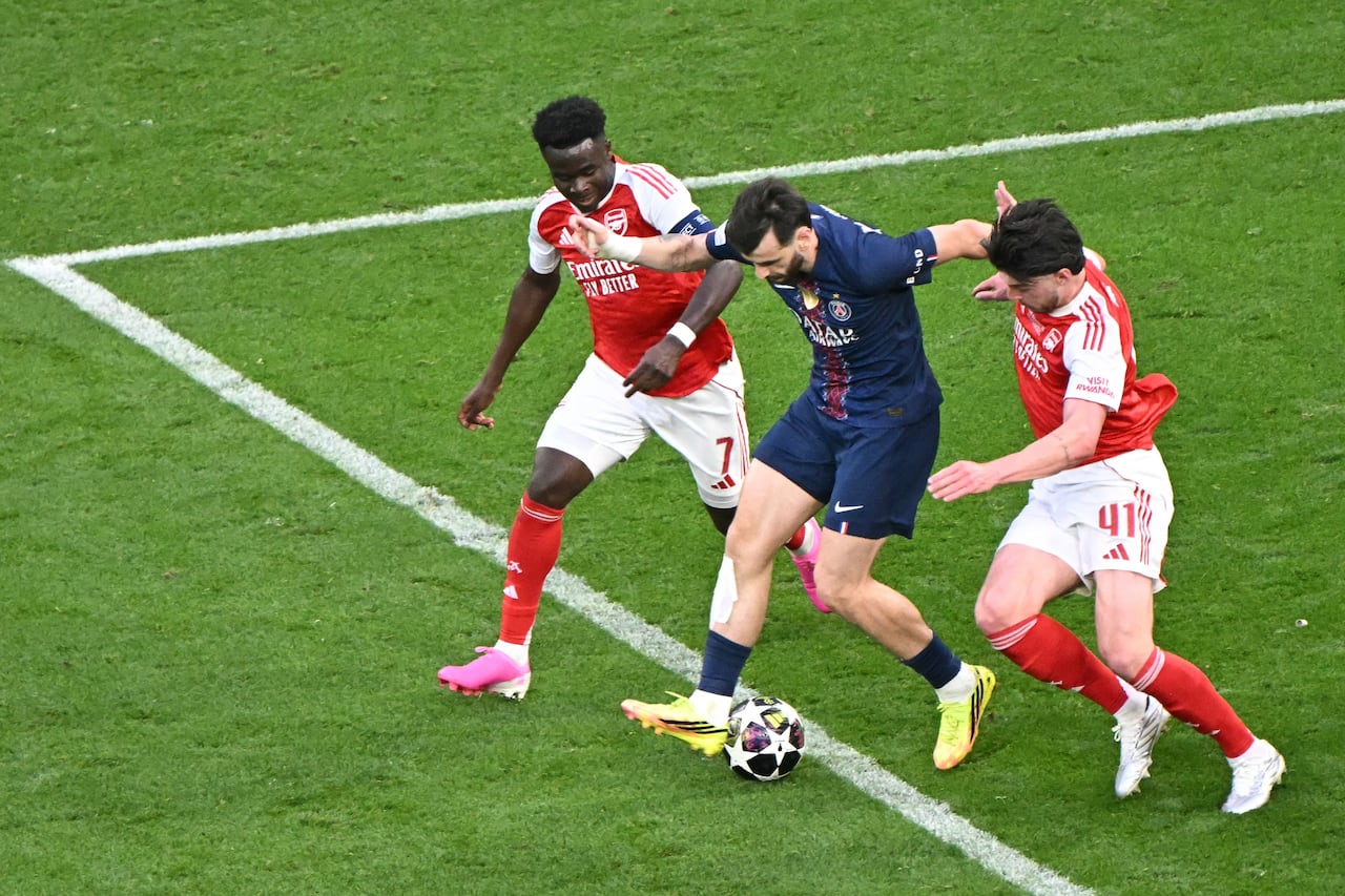 El delantero georgiano del Paris Saint-Germain, Khvicha Kvaratskhelia (C), disputa el balón con el centrocampista inglés del Arsenal, Bukayo Saka (C), y el centrocampista inglés del Arsenal, Declan Rice (C41), durante la final de la Liga de Campeones de la UEFA entre el Paris Saint-Germain (PSG) y el Arsenal FC en el Puskas Arena de Budapest el 30 de mayo de 2026. (Foto de Attila KISBENEDEK / AFP)