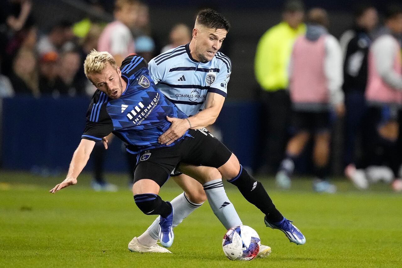 El defensa del Sporting Kansas City, Andreu Fontàs, derecha, y el mediocampista de los San Jose Earthquakes, Jackson Yueill, se enredan mientras persiguen el balón durante la segunda mitad de un partido de playoffs de comodines de la MLS el miércoles 25 de octubre de 2023 en Kansas City, Kansas. Sporting KC ganó en tiros penales y avanzó a los playoffs. (Foto AP/Charlie Riedel)