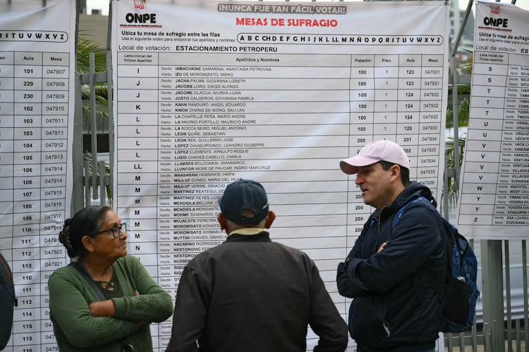 Personas esperan para votar afuera de un centro de votación en Lima el 12 de abril de 2026, durante las elecciones generales.