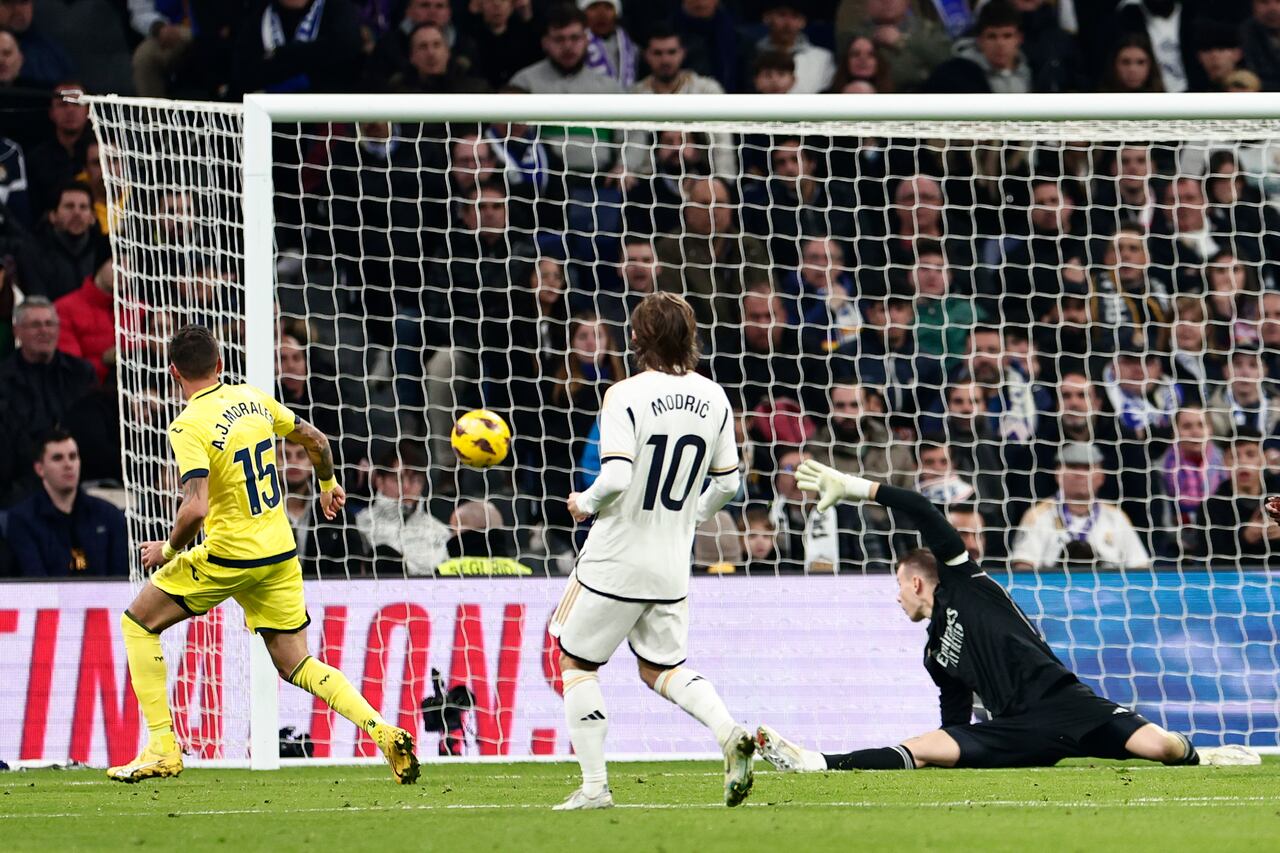 José Luis Morales, de Villarreal, izquierda, anota el primer gol de su equipo ante el portero del Real Madrid Andriy Lunin durante el partido de fútbol de la Liga española entre Real Madrid y Villarreal en el estadio Santiago Bernebeu en Madrid, España, el domingo 17 de diciembre de 2023. (AP Foto/Pablo García)