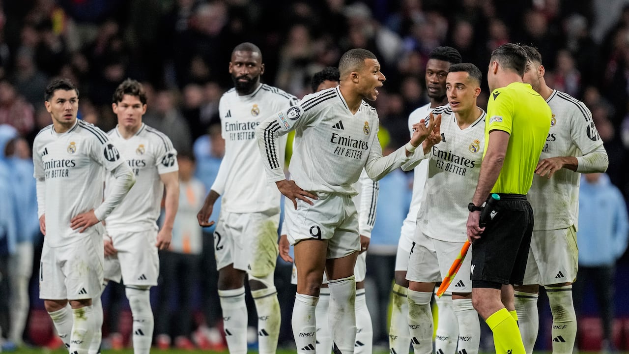 Real Madrid's Kylian Mbappe, center, talks to an assistant referee after a penalty kick by Atletico Madrid's Julian Alvarez during a shootout at the end of the Champions League round of 16, second leg, soccer match between Atletico Madrid and Real Madrid at the Metropolitano stadium in Madrid, Spain, Wednesday, March 12, 2025. (AP Photo/Bernat Armangue)