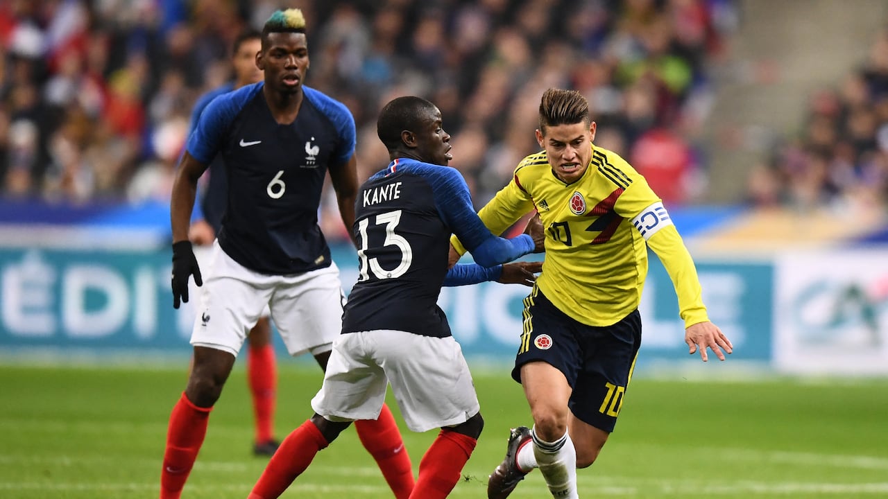 El centrocampista francés Paul Pogba (izq.) observa al centrocampista francés N'Golo Kanté (centro) disputar el balón con el centrocampista colombiano James Rodríguez durante el partido amistoso de fútbol entre Francia y Colombia en el Stade de France, en Saint-Denis, a las afueras de París, el 23 de marzo de 2018. (Foto de FRANCK FIFE / AFP)