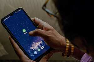 This photo illustration shows a woman checking the settings of the messaging application WhatsApp, in Bangalore on October 25, 2022, after the application was hit by a global outage, according to reports by monitoring site Downdetector and user complaints on social media. (Photo by Manjunath KIRAN / AFP)