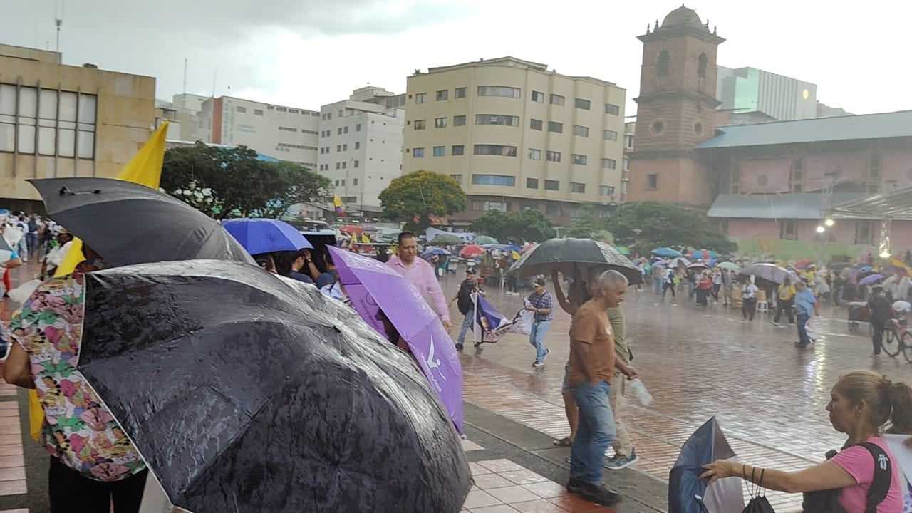 Marchantes en Cali, fueron sorprendidos por un fuerte aguacero este jueves.