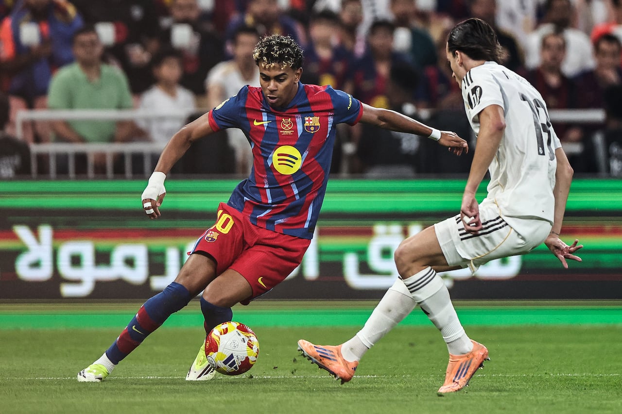 El delantero español #10 del Barcelona, Lamine Yamal (izq.), y el defensa español #18 del Real Madrid, Álvaro Carreras, luchan por el balón durante la final de la Supercopa de España entre el FC Barcelona y el Real Madrid en el Estadio Rey Abdullah en Yeddah el 11 de enero de 2026. (Foto de Fadel SENNA / AFP)