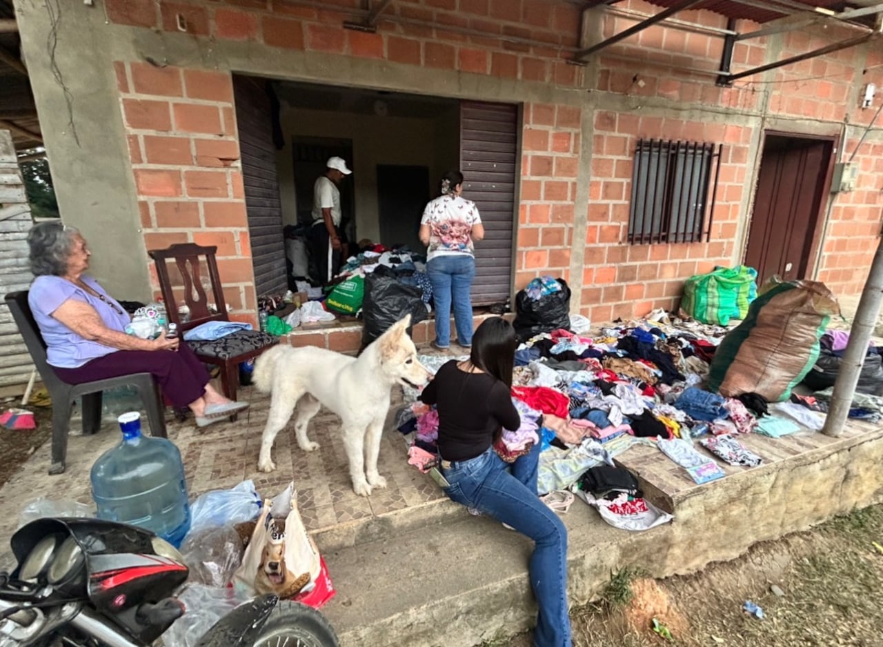 Familias que lo perdieron todo, ayudan en medio del drama a clasificar las prendas de vestir que han llegado como donaciones.