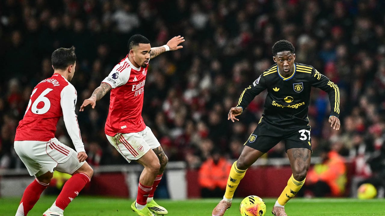 El centrocampista inglés #37 del Manchester United, Kobbie Mainoo (derecha), intenta un pase durante el partido de la Premier League inglesa entre el Arsenal y el Manchester United en el Emirates Stadium de Londres el 25 de enero de 2026. (Foto de Ben STANSALL / AFP)