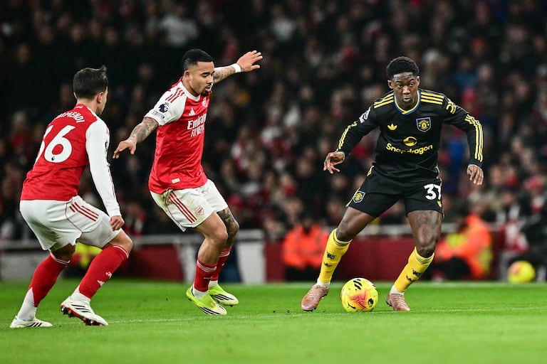 El centrocampista inglés #37 del Manchester United, Kobbie Mainoo (derecha), intenta un pase durante el partido de la Premier League inglesa entre el Arsenal y el Manchester United en el Emirates Stadium de Londres el 25 de enero de 2026. (Foto de Ben STANSALL / AFP)