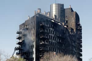 Los bomberos refrescan el bloque residencial de varias plantas devastado ayer por un enorme incendio que mató al menos a cuatro personas, en Valencia el 23 de febrero de 2024. Al menos cuatro personas han muerto en un gran incendio que arrasó un bloque de apartamentos de 14 plantas en Valencia en este de España, pero las autoridades advirtieron hoy que el número de muertos podría aumentar considerablemente. Catorce personas siguen desaparecidas, afirmó el administrador regional. (Foto de JOSÉ JORDANIA / AFP)