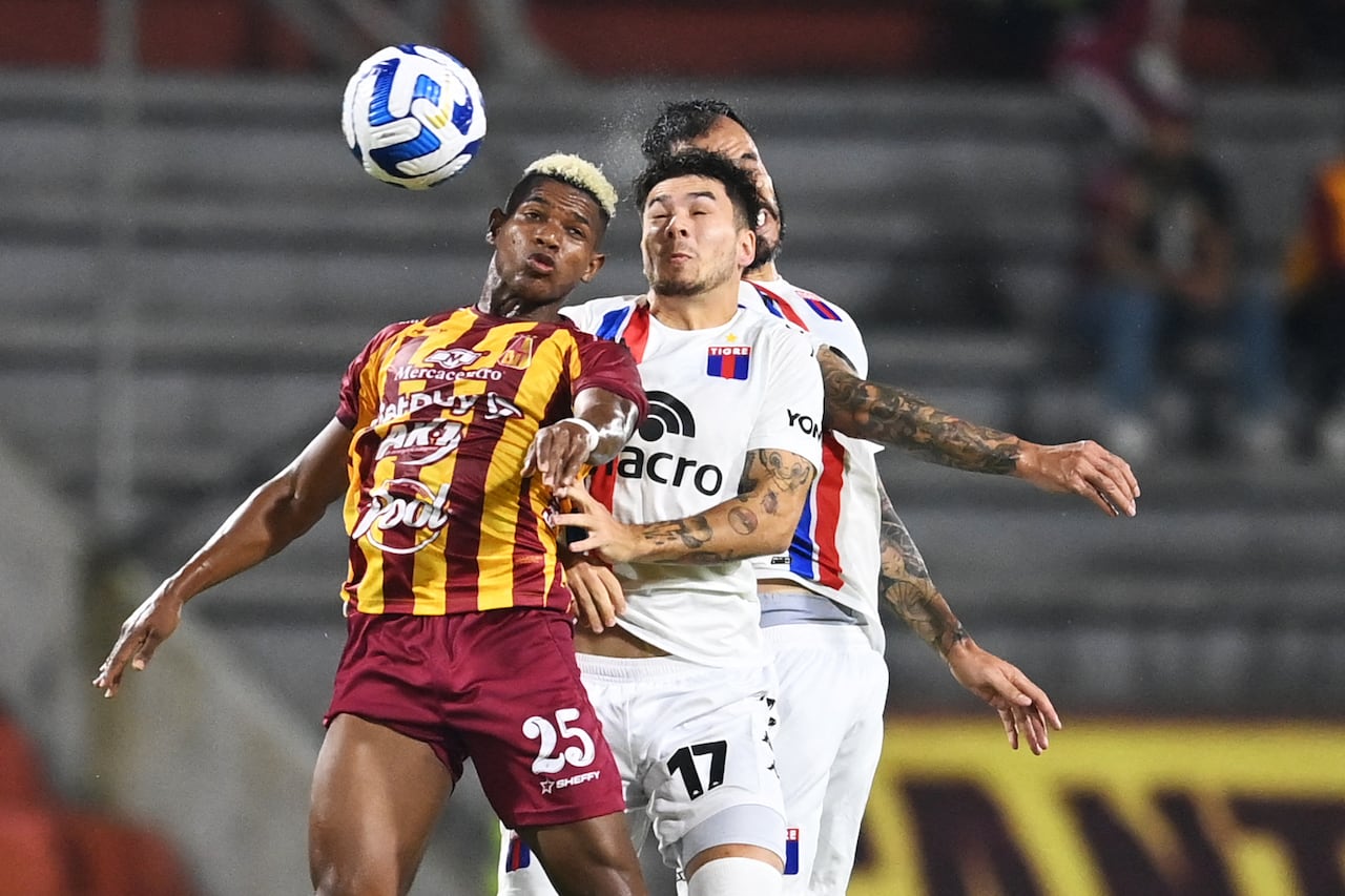 El mediocampista del Tolima Kevin Pérez (L) y el defensor de Tigre Lucas Blondel disputan el balón durante un partido de la Copa Sudamericana.