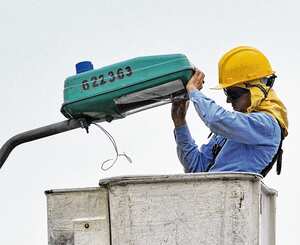 Operario de Emcali realiza trabajos en uno de los postes de la ciudad. Con el resurgimiento de Caligen, esta empresa operaría el alumbrado público.