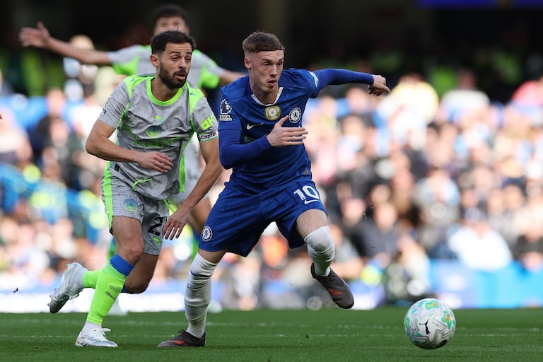 El centrocampista inglés del Chelsea, Cole Palmer (derecha), número 10, le gana la posesión del balón al centrocampista portugués del Manchester City, Bernardo Silva (número 20), durante el partido de la Premier League inglesa entre el Chelsea y el Manchester City en Stamford Bridge, Londres, el 12 de abril de 2026. (Foto de Adrian Dennis / AFP)