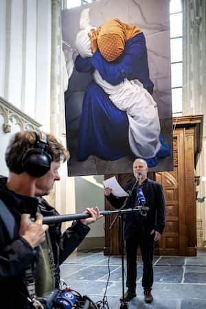 El editor fotográfico global de Reuters, Rickey Rogers (derecha), lee una declaración del ganador del premio World Press Photo, el fotógrafo palestino de Reuters, Mohammed Salem, sobre su fotografía "Una mujer palestina abraza el cuerpo de su sobrina" después de recibir el premio 2024. Premio World Press Photo del año, en la Iglesia Nueva de Ámsterdam el 18 de abril de 2024. (Foto de Robin van Lonkhuijsen / ANP / AFP) / Países Bajos FUERA / USO RESTRINGIDO A EDITORIAL - MENCIÓN OBLIGATORIA DEL ARTISTA EN EL MOMENTO DE LA PUBLICACIÓN - PARA ILUSTRAR EL EVENTO COMO SE ESPECIFICA EN EL TÍTULO