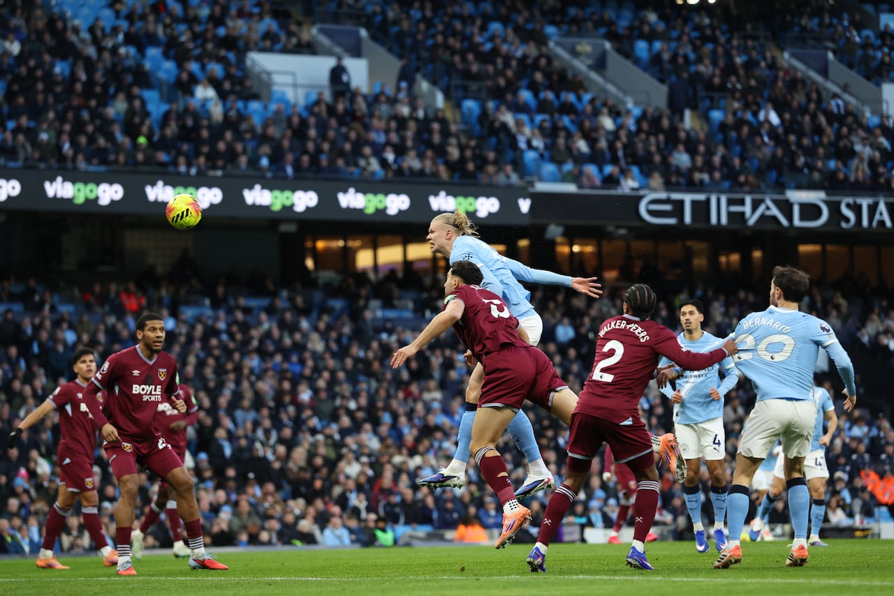 El delantero noruego #09 del Manchester City, Erling Haaland (centro), falla un cabezazo durante el partido de la Premier League inglesa entre el Manchester City y el West Ham United en el Etihad Stadium de Manchester, noroeste de Inglaterra, el 20 de diciembre de 2025. (Foto de Darren Staples / AFP)