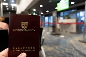 Primer plano de un pasaporte colombiano en el fondo de un aeropuerto.