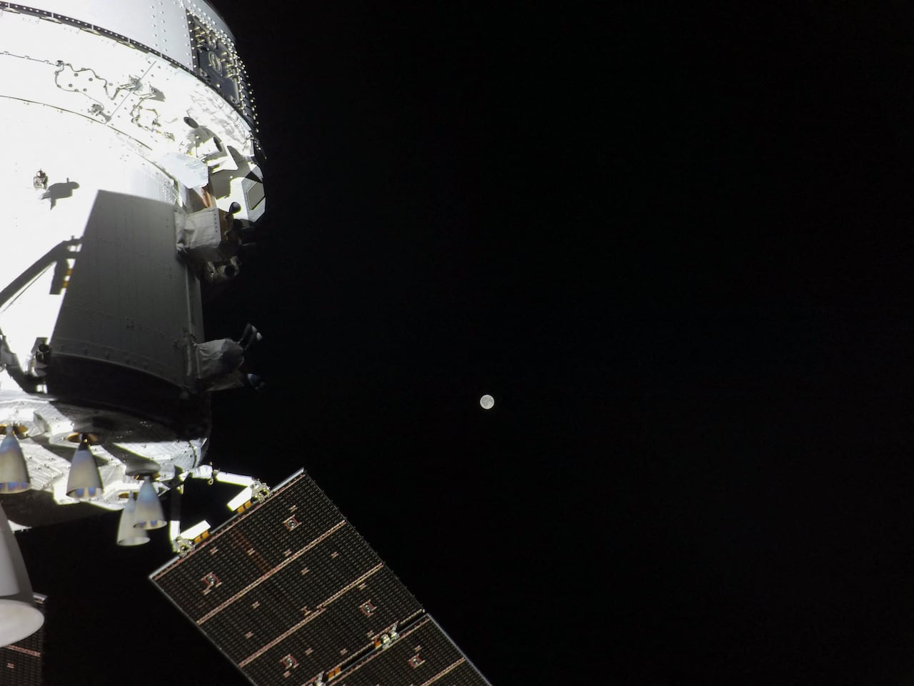 Esta imagen proporcionada por la NASA muestra la nave espacial Orion con la Luna en la distancia, capturada por una cámara en la punta de una de sus alas del panel solar, el 3 de abril de 2026. Mientras los astronautas Artemis II avanzaban en su misión lunar, la NASA publicó imágenes iniciales tomadas desde la nave espacial Orion, incluido un retrato completo de la Tierra con sus océanos de un azul profundo y sus nubes ondulantes. Después de una ráfaga de actividad de alto riesgo que incluyó un espectacular despegue y el encendido de un motor que los catapultó en su trayectoria histórica para rodear la Luna, los cuatro astronautas a bordo pudieron recuperar el aliento, incluso mientras continuaban realizando una variedad de comprobaciones y pruebas de equipos. (Foto de NASA/AFP) / RESTRINGIDO A USO EDITORIAL - CRÉDITO OBLIGATORIO "AFP PHOTO/NASA" - NO HAY MARKETING NO HAY CAMPAÑAS PUBLICITARIAS - DISTRIBUIDO COMO SERVICIO A LOS CLIENTES