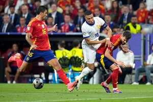 Kylian Mbappé de Francia, centro, y el español Nacho, derecha, desafían el balón durante un partido de semifinal entre España y Francia en el torneo de fútbol Euro 2024 en Munich, Alemania, el martes 9 de julio de 2024. Izquierda, el español Rodri. (Foto AP/Hassan Ammar)