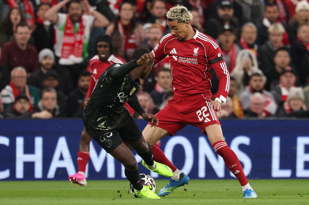 El delantero francés del Liverpool, Hugo Ekitike (derecha), número 22, disputa el balón con el defensa portugués del Paris Saint-Germain, Nuno Mendes (izquierda), número 25, durante el partido de vuelta de los cuartos de final de la Liga de Campeones de la UEFA entre el Liverpool y el Paris Saint-Germain en Anfield, Liverpool, al noroeste de Inglaterra, el 14 de abril de 2026. (Foto de FRANCK FIFE / AFP)