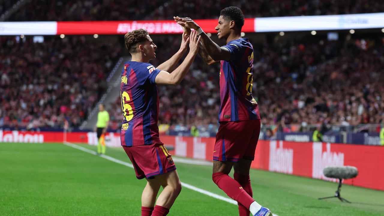 El delantero inglés del Barcelona, Marcus Rashford (derecha), número 14, celebra el primer gol de su equipo con el centrocampista español del Barcelona, Fermín López (número 16), durante el partido de la liga española entre el Club Atlético de Madrid y el FC Barcelona en el Estadio Metropolitano de Madrid el 4 de abril de 2026. (Foto de Pierre-Philippe MARCOU / AFP)