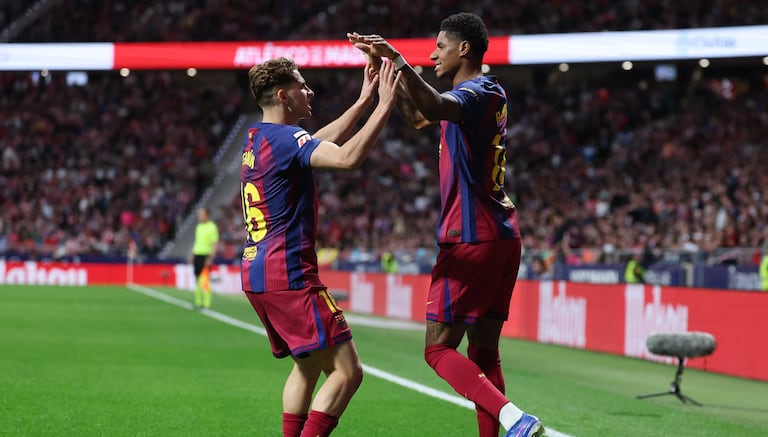El delantero inglés del Barcelona, Marcus Rashford (derecha), número 14, celebra el primer gol de su equipo con el centrocampista español del Barcelona, Fermín López (número 16), durante el partido de la liga española entre el Club Atlético de Madrid y el FC Barcelona en el Estadio Metropolitano de Madrid el 4 de abril de 2026. (Foto de Pierre-Philippe MARCOU / AFP)