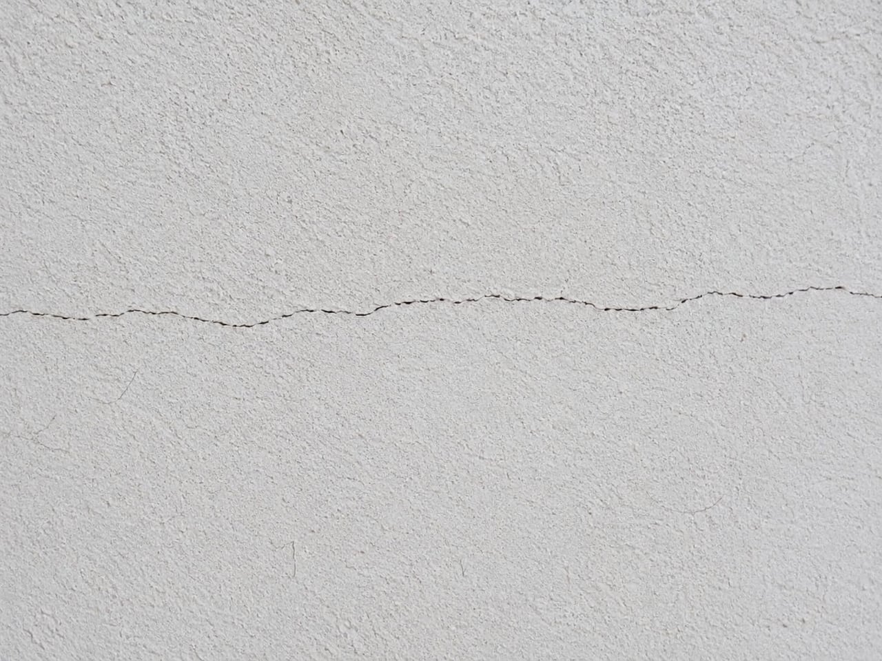 Una fisura fina y superficial que afecta únicamente el acabado de la pared, como el pañete o la pintura, generalmente no representa un riesgo estructural.